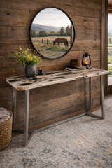 Rustic interior with wooden console table, round mirror reflecting a horse, and decorative items.